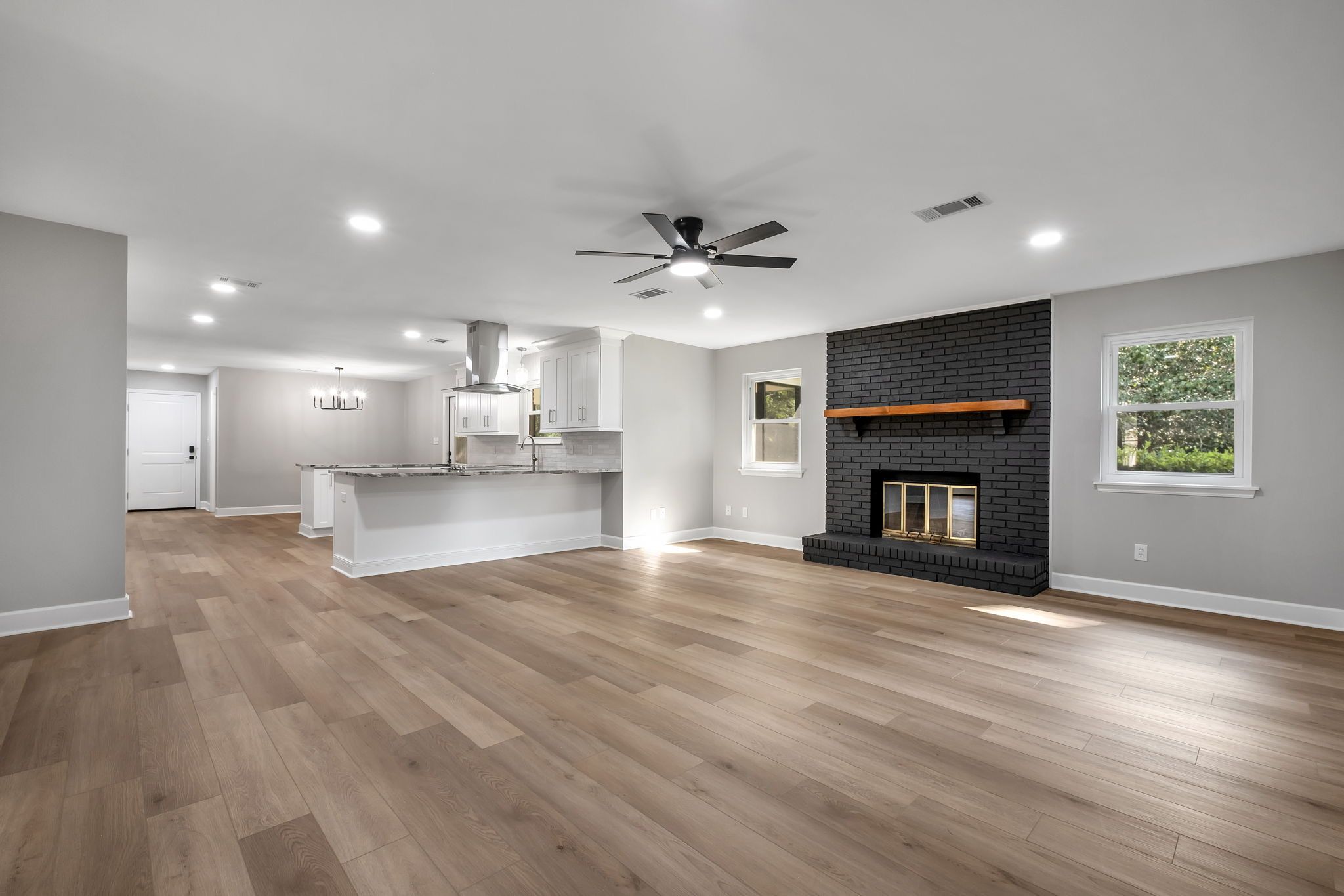 The same living room unfurnished, looking through to the kitchen and dining area