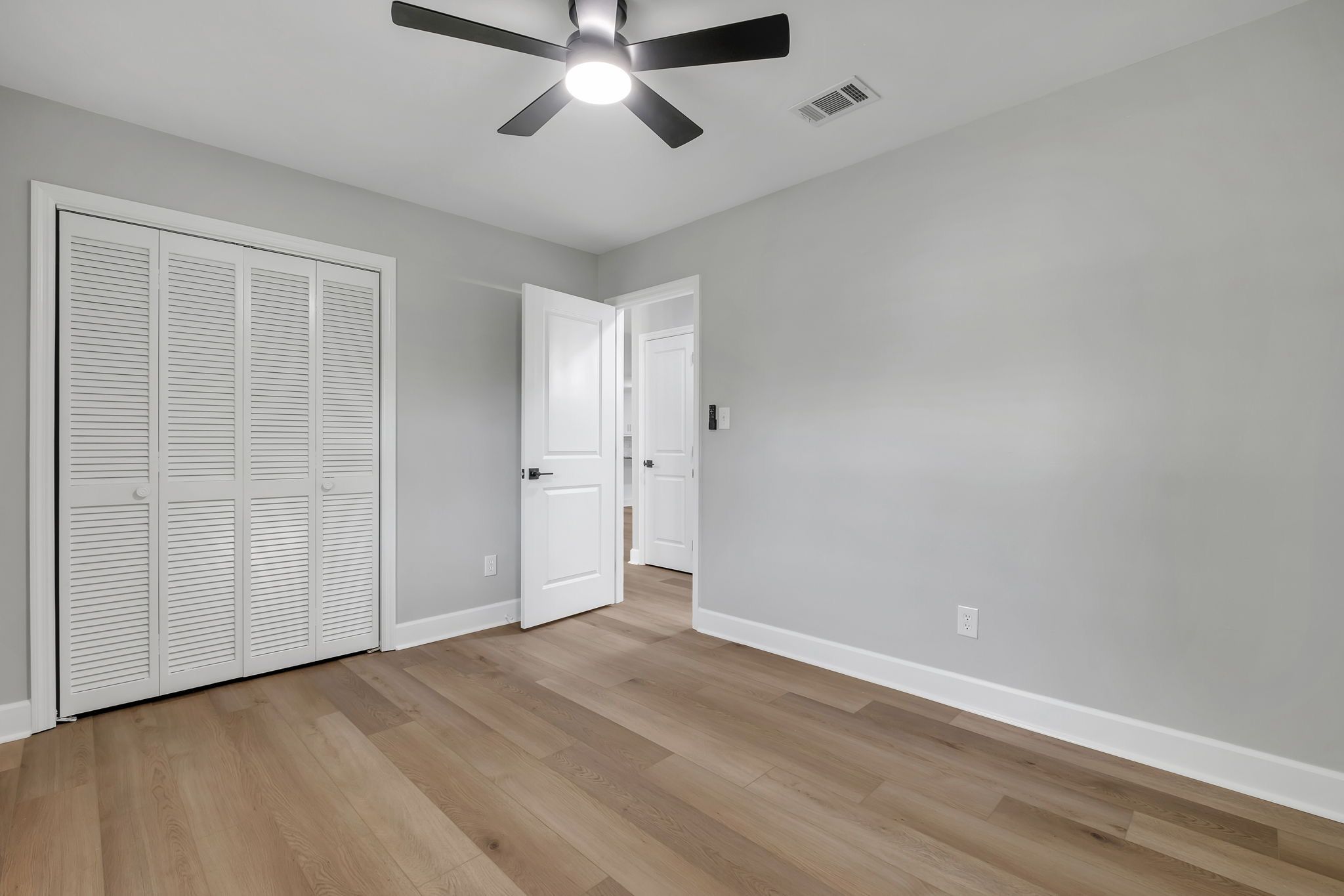 One of the three additional bedrooms, with a double closet and a ceiling fan