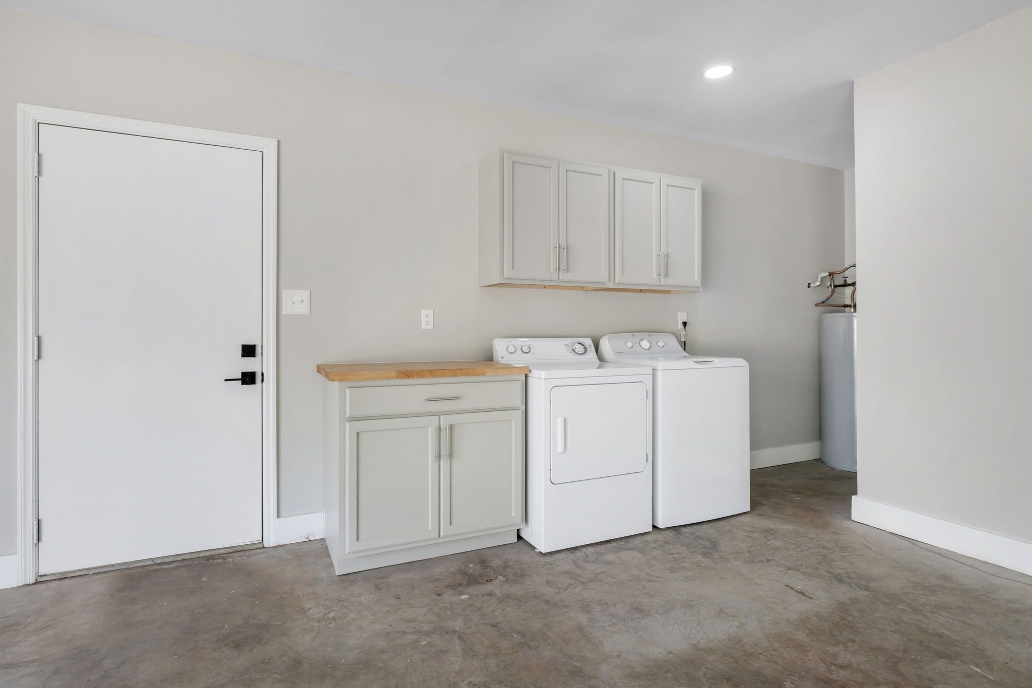 Laundry area in the oversized garage, with the washer, dryer, and a butcher-block folding counter